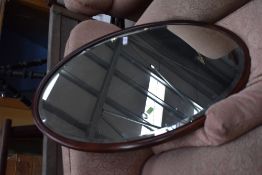 An early 20th Century mahogany oval wall mirror, width approx. 79cm