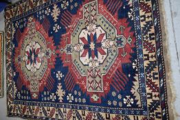 A Persian rug, in crimson, blue and cream, approx. 192 x 136cm
