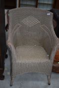 A vintage Lloyd Loom or similar chair, in beige with patterned back