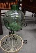 A carboy on stand and a planter holder