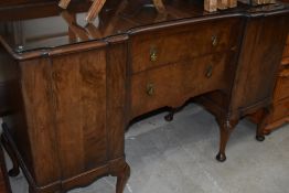 An early to mid 20th Century mahogany or dark walnut sideboard having shaped top