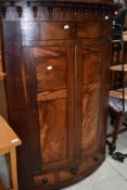A 19th Century mahogany bow fronted corner cupboard having drawer base (single drawer flanked by two
