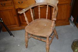 A traditional stripped spindle back elbow chair