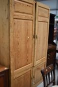 An Antique pine panelled double cupboard/robe with cupboard base, dimensions approx. W127cm D40cm