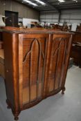 An early 20th Century stained frame display cabinet having serpentine front, width approx. 105cm