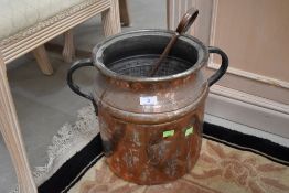 An antique copper vessel , having cast handles and tongs, includes coal
