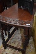 A mid 20th Century oak twist gate leg dining table with carved decoration