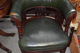 A Victorian mahogany and green leather tub chair