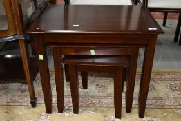 A modern nest of three mahogany tables