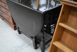A traditional dark oak gateleg table, width approx. 90cm