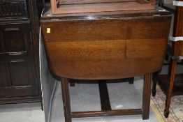 A dark stained Ercol style drawer leaf dining table, approx. width 47cm