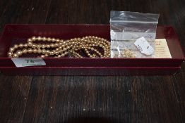 A Faux pearl necklace and a yellow metal chain.