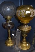 Two late 19th early 20th oil lamps having decorative glass shades and brass bases.