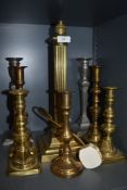 A selection of heavy set candle sticks and brass roman column lamp.