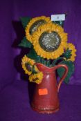 A cast door stop with design of sunflowers in jug.