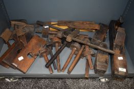 A shelf full of vintage tools including planes and marking tools.
