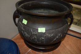 an early 20th century Chinese export cache pot or planter having raised reliefe of village scenes