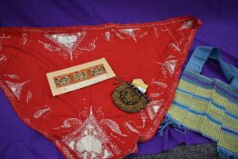 A red Victorian Fichu with white embroidery, a purple velvet drawstring bag with filigree thread