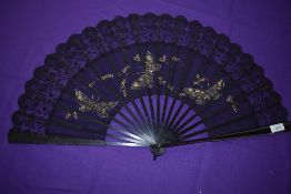 A black gauze and lace fan, circa 1890, with painted butterflies and trimmed with sequins having