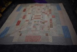A large Antique patchwork quilt, using various colourful sections of cotton, some of the backing