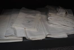 A collection of vintage and antique white table linen some damask and some having embroidery and