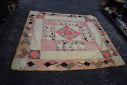 A large Victorian patchwork quilt, using various wool and wool blend fabrics, around a double in