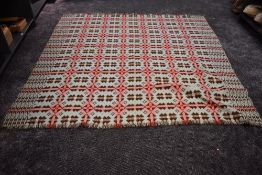 A large vintage Welsh wool blanket with fringed edging in brown, pink and duck egg tones.