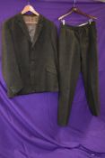 A gents 1950s single breasted tweed suit in muted green tones, fully lined, label reads; Continental