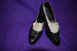 A pair of antique black leather and cream suede shoes with stack heel and mother of pearl button