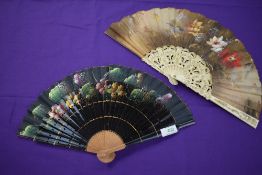 Two hand painted fans having floral scenes to fabric, one having lacquered ribs and the other