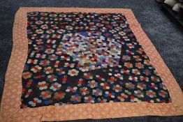 A stunning Victorian patchwork quilt having hexagons to centre surrounded by a border. beautifully