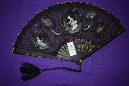 A Victorian black gauze and net fan having painted inserts depicting ladies and countryside scenes.