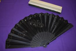 A large boxed early 20th century black silk fan with sequins and spangles forming butterflies to the