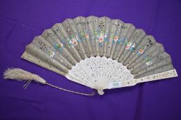 A silver gauze fan painted with flowers and having sequins and spangles, with pierced bone ribs
