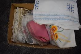 A box full of vintage and antique table line and bed linen, including crotchet edged pillow cases