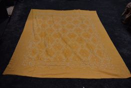 A large vintage bed throw in ochre and white, with busy woven pattern of flowers,Greek key shapes