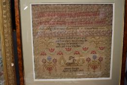 A framed sampler by emma Coupe, aged 10 1862, depicting a deer,alphabet, religious text,and floral