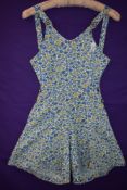 A 1940s cotton playsuit having bright floral print, buttons to both sides and buttons to front of