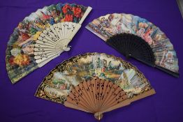 Three colourful paper fans having wooden ribs depicting Spanish scenes and similar, around mid