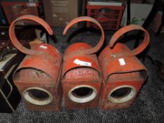 Three vintage red road lamps.