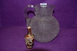 A Fosted glass water jug and a small oriental styled vase.