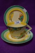 A Clarice Cliff trio having sea and landscapes to cup and plate and green and yellow banding to