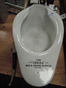 A vintage bed pan and an ornate letter opener.