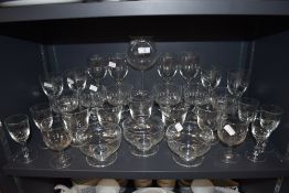 A selection of clear cut and etched glass wares including sundae bowls and wine glasses