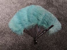 A vintage ostrich feather fan having teal blue colour and early plastic ribs.