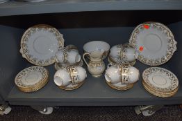 An elegant part tea service un named but stamped 890 having floral gilt transfer with blue enamel