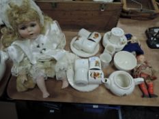 A 1950s childrens tea set with transfer pixie type pattern and three dolls.