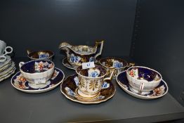 A selection of antique tea cups and milk jug including hard paste with individual hand decorated