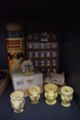 A selection of advertising thimbles and character egg cups