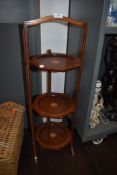 A folding cake or tea stand in mahogany with banding and inlay detail